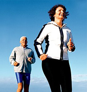 Older couple running on beach.