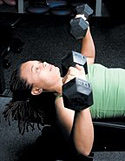 Chelsea Cooper performing flat bench dumbbell chest press.