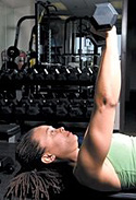 Chelsea Cooper performing flat bench dumbbell chest press.