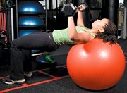 Chelsea Cooper performing stability ball barbell press.