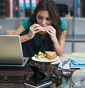 Woman eating at her work desk.