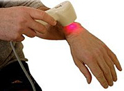 Therapist using low-level laser therapy on his wrist.