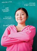 Girl standing in front of blackboard with arms folded.