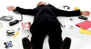 Office worker spread-eagle on the ground surrounded by office supplies.