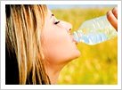 Woman drinking from water bottle.