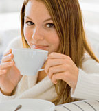 Young woman dringing a cup of hot herbal tea.