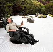 Man sitting in massage chair on zen sand garden.